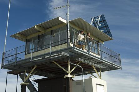 two people stand on platform of lookout tower