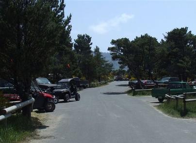 RV park campground with vehicles parked on both sides of paved drive