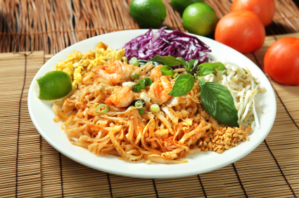plate of noodles with shrimp, cabbage, bean sprouts and lime wedge