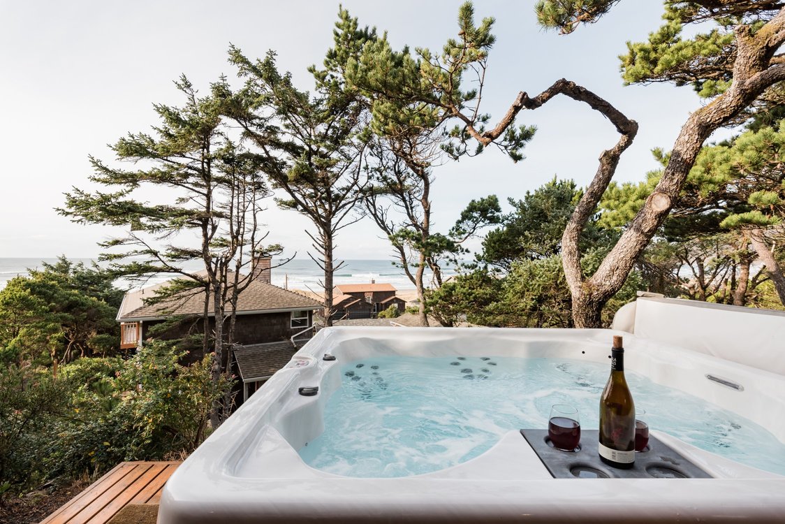 soaking tub on deck with view of ocean