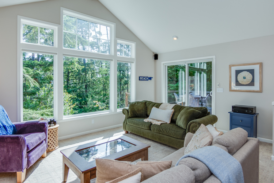 living room with two couches, one chair and coffee table and tall windows