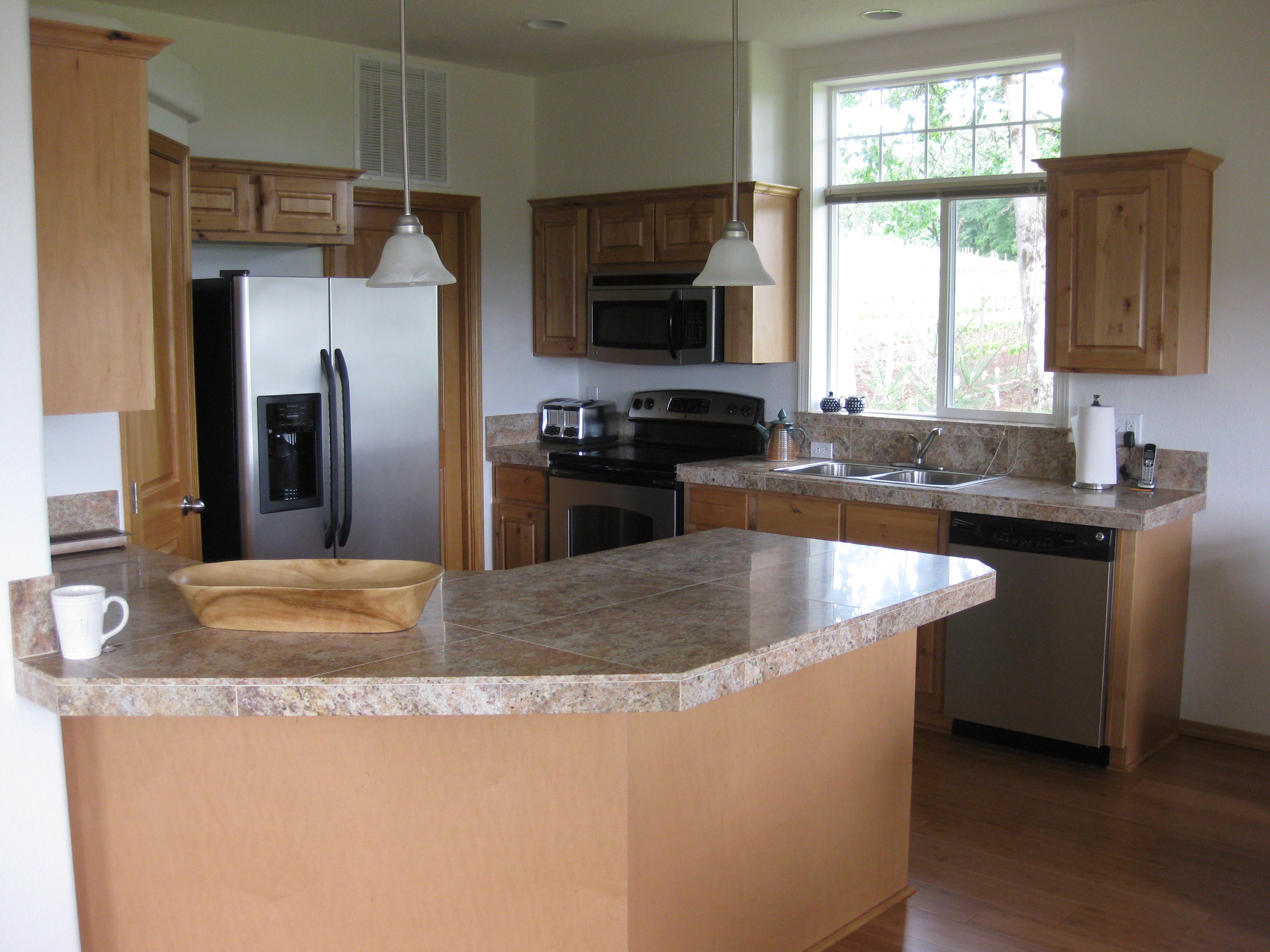 small kitchen with marble countertops and stainless steel appliances