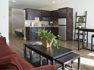 kitchen and sitting area of guest room of hotel