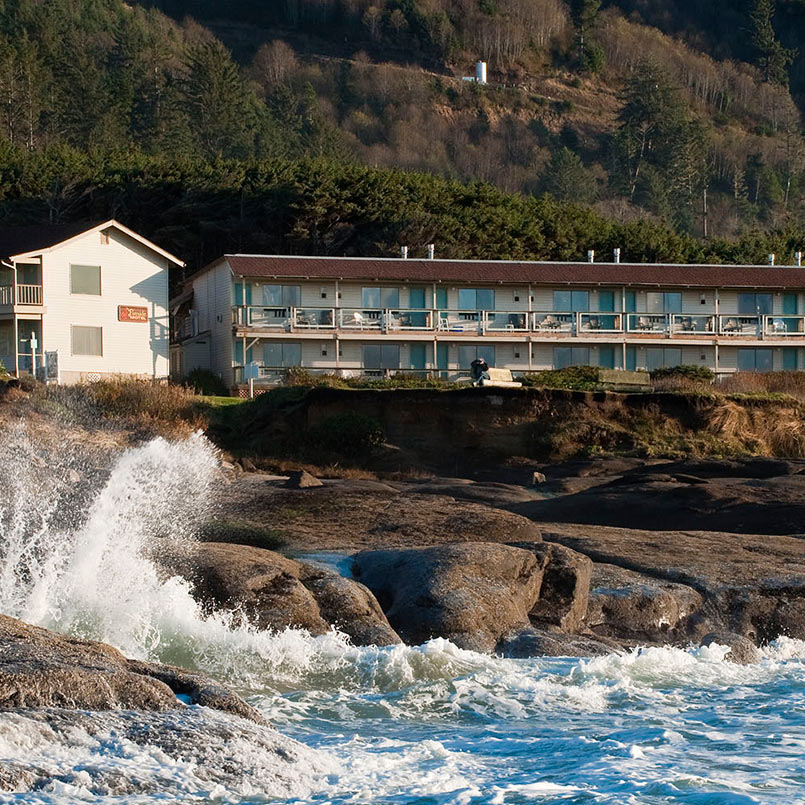two story hotel on banks of rocky beach