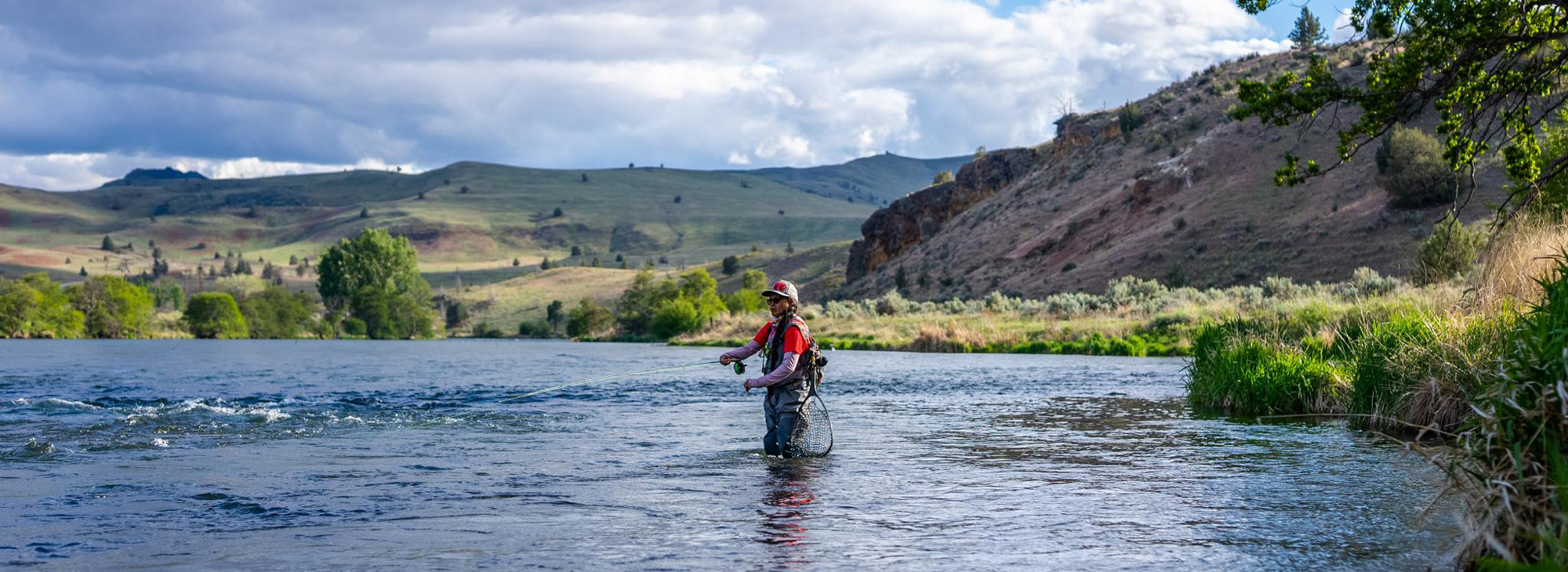Person fly fishing in the deschutes river.