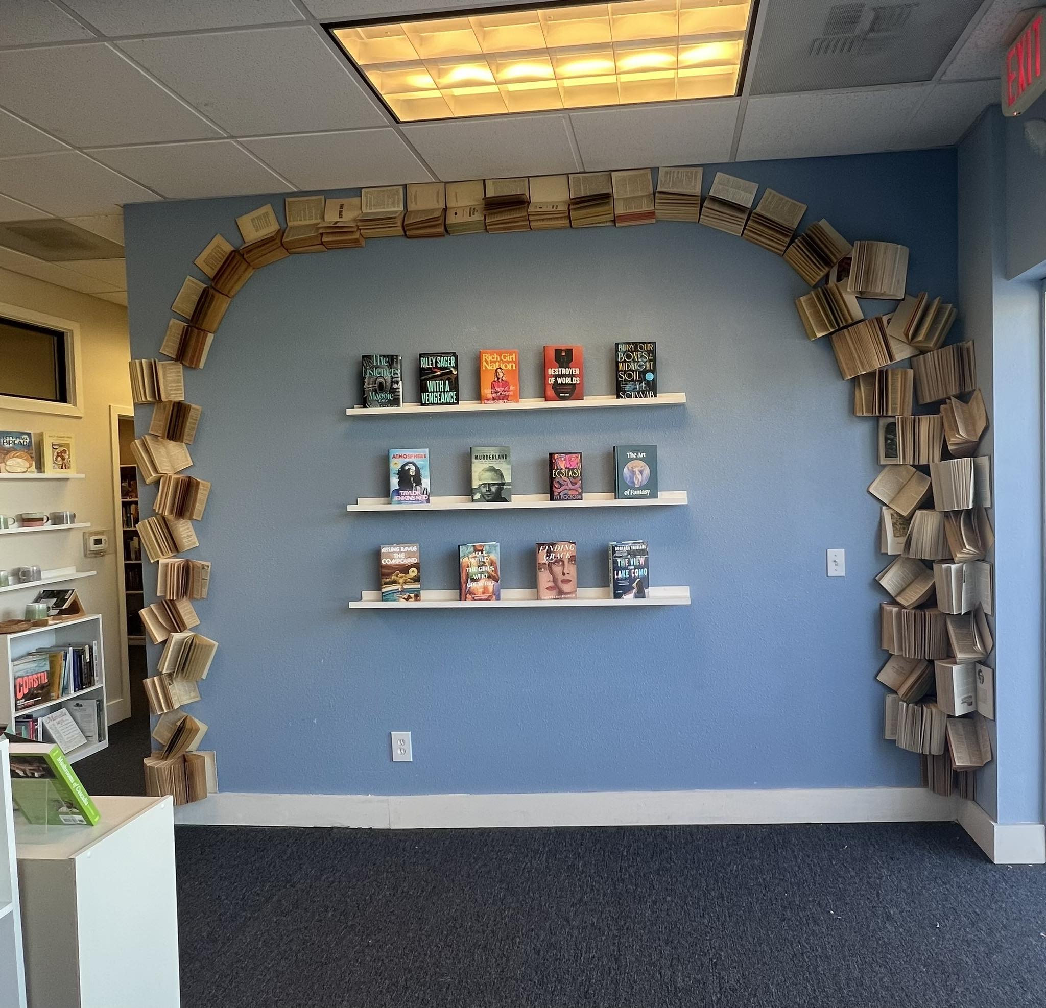 Blue wall with a tower of books at Oliver Books in Prineville, Oregon