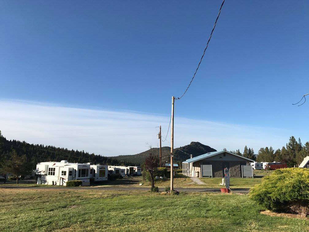picture of rv camp trailers with blue sky and green grass
