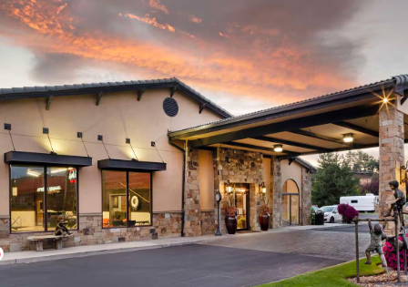 tan building with covered carport with brick accents