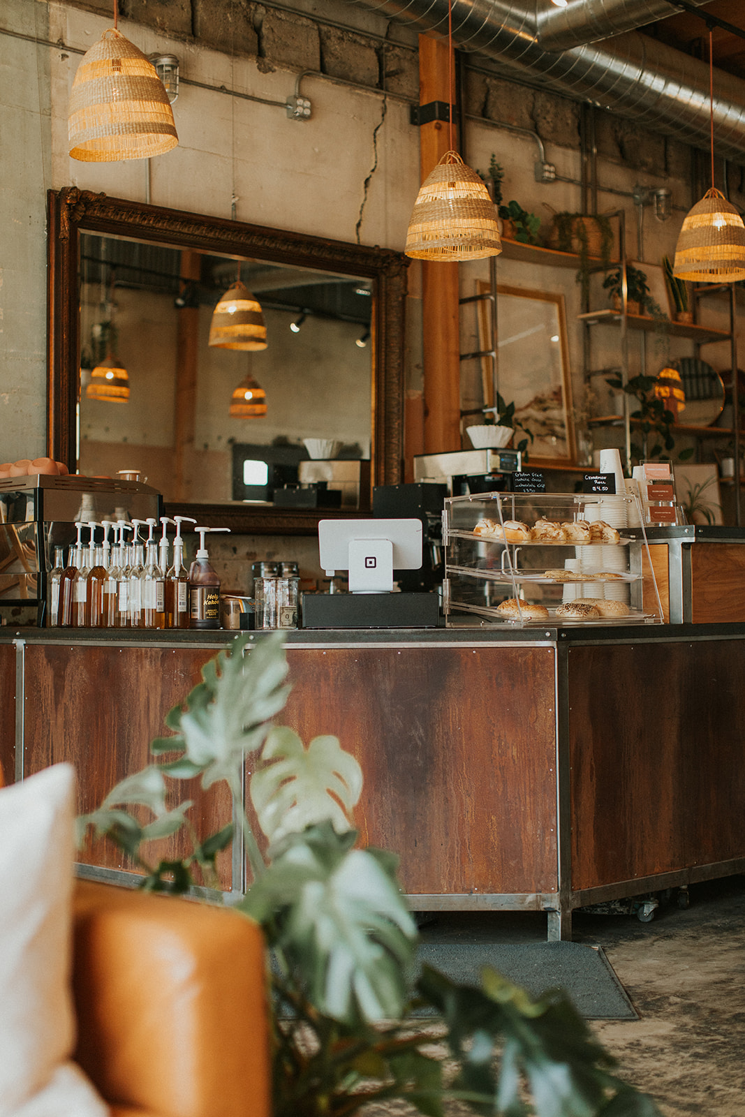 Hanging wicker lights at industrial coffee shop with brick walls and beams and rustic counter at Golden Coffee In Prineville