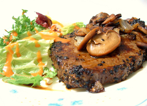 Steak with mushrooms, onions, and a salad.