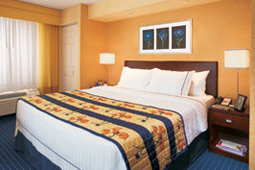 Bedroom with bed, lamps, and artwork on wall.