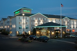 Holiday Inn hotel entrance with cars parked.