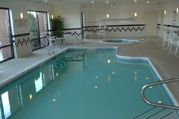 Large indoor pool with steps and a small jacuzzi.