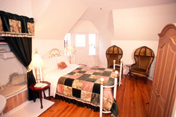 guest room with double bed, two chairs and bureau