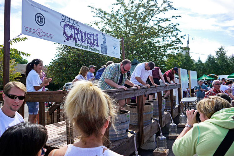 group on an outdoor stage participates in grape stomping competition