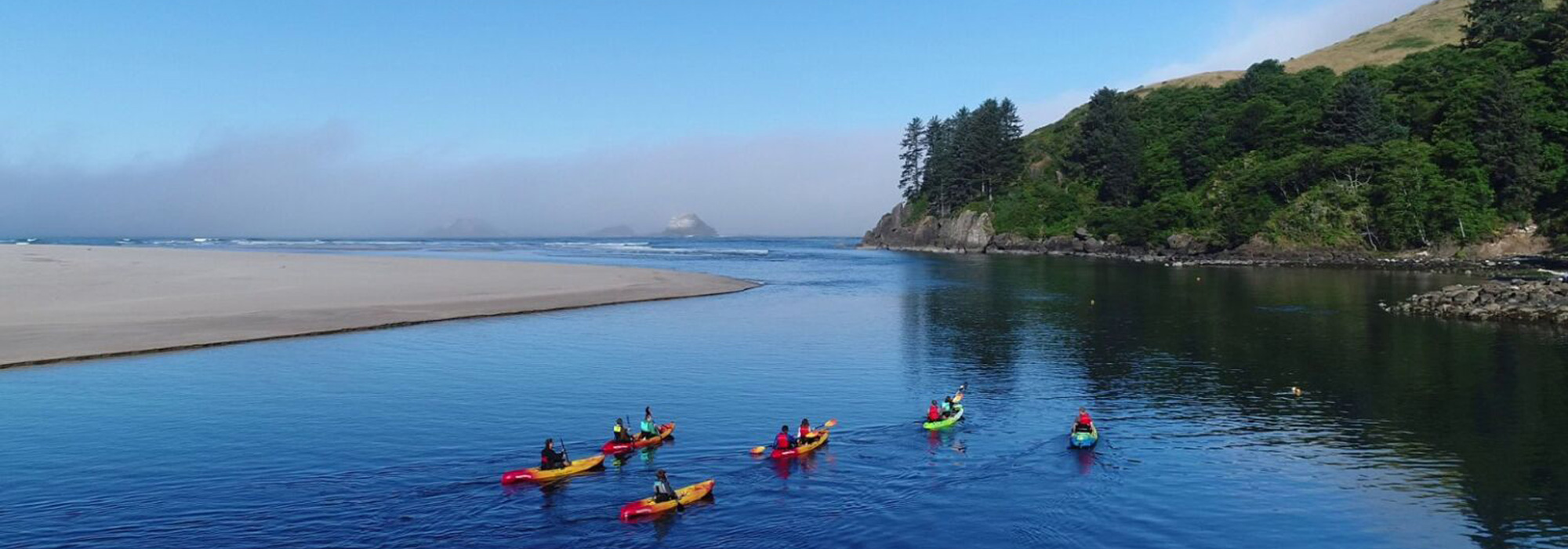 group of kayakers paddle on calm water