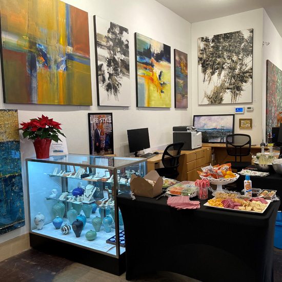 gift shop area of art gallery with paintings on wall behind display case