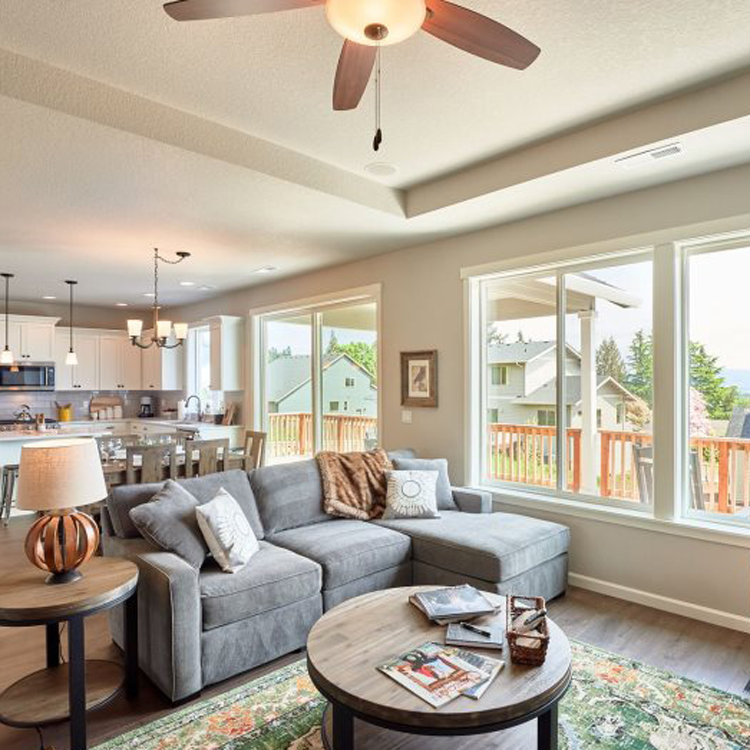 open concept living room and kitchen with ceiling fan and lots of windows