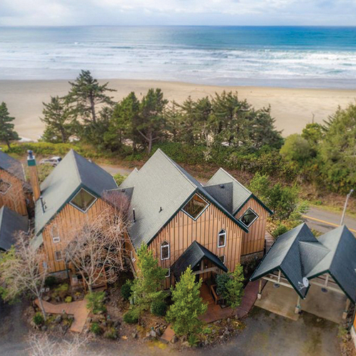 aerial view of two story house with ocean in background