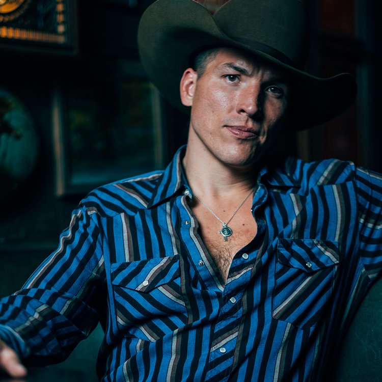 portrait of man wearing cowboy style button down shirt and cowboy hat