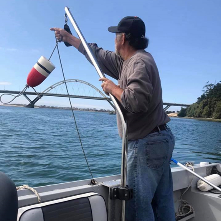 person tossing buoy over side of motor boat