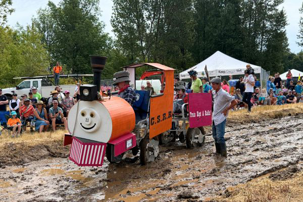 A pedal powered machine rolls through muddy pathway.