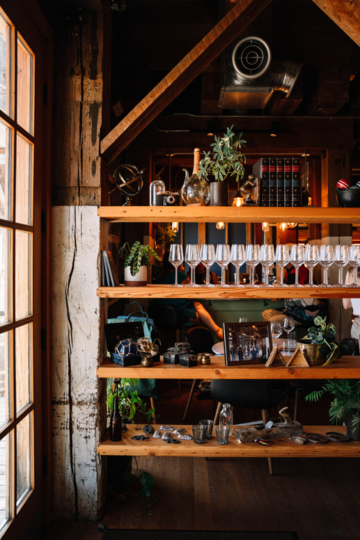 stylish wood shelving displaying wine glasses and keepsakes