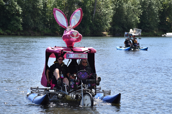 Pedal powered machine floats on small body of water.