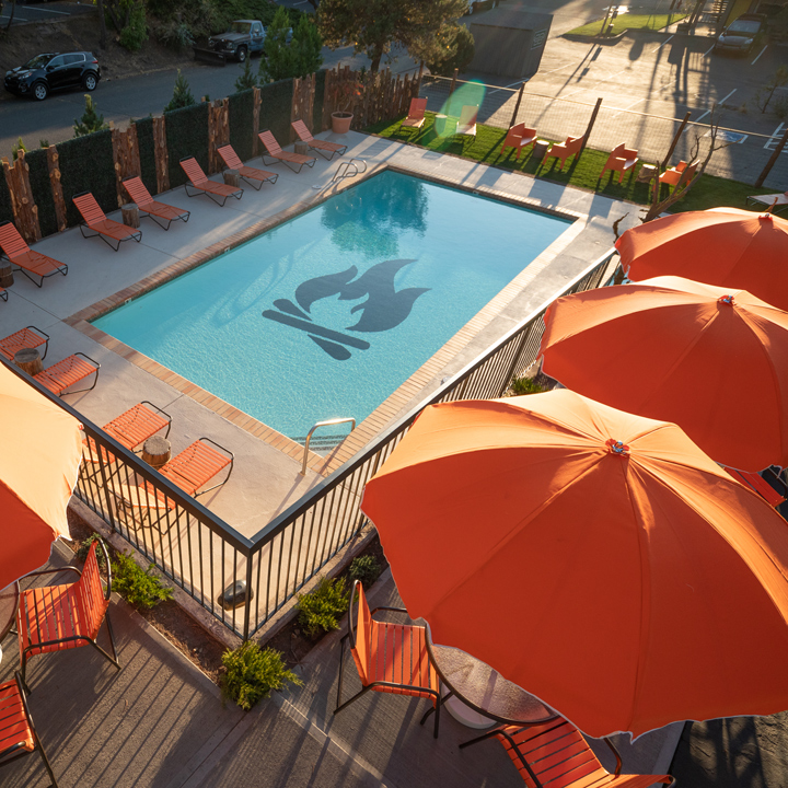 outdoor pool surrounded by patio chairs and umbrellas