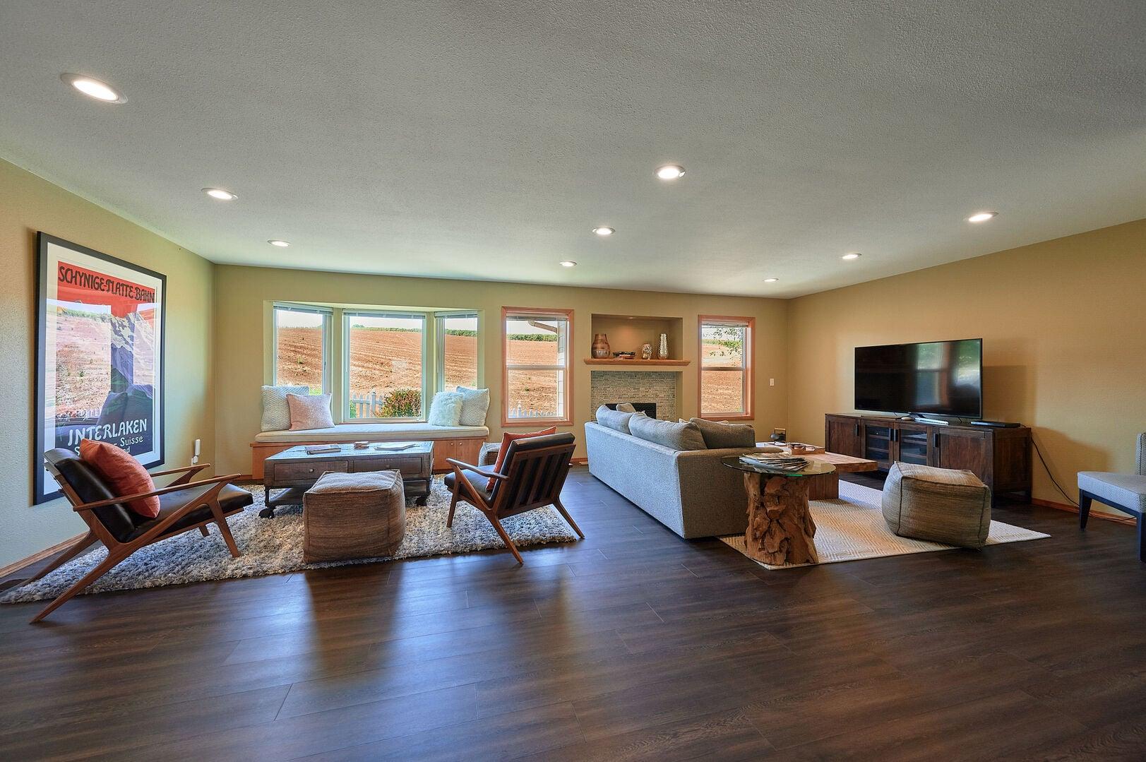 Spacious living room featuring modern furniture and a flat-screen TV on a wooden stand.