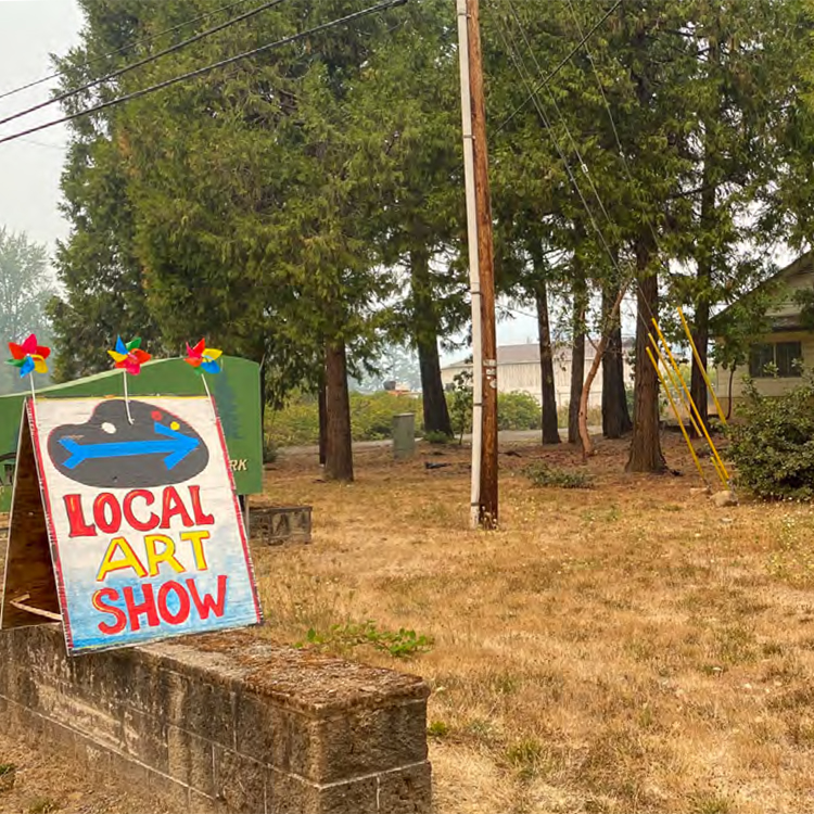 sign for local art show with arrow pointing right