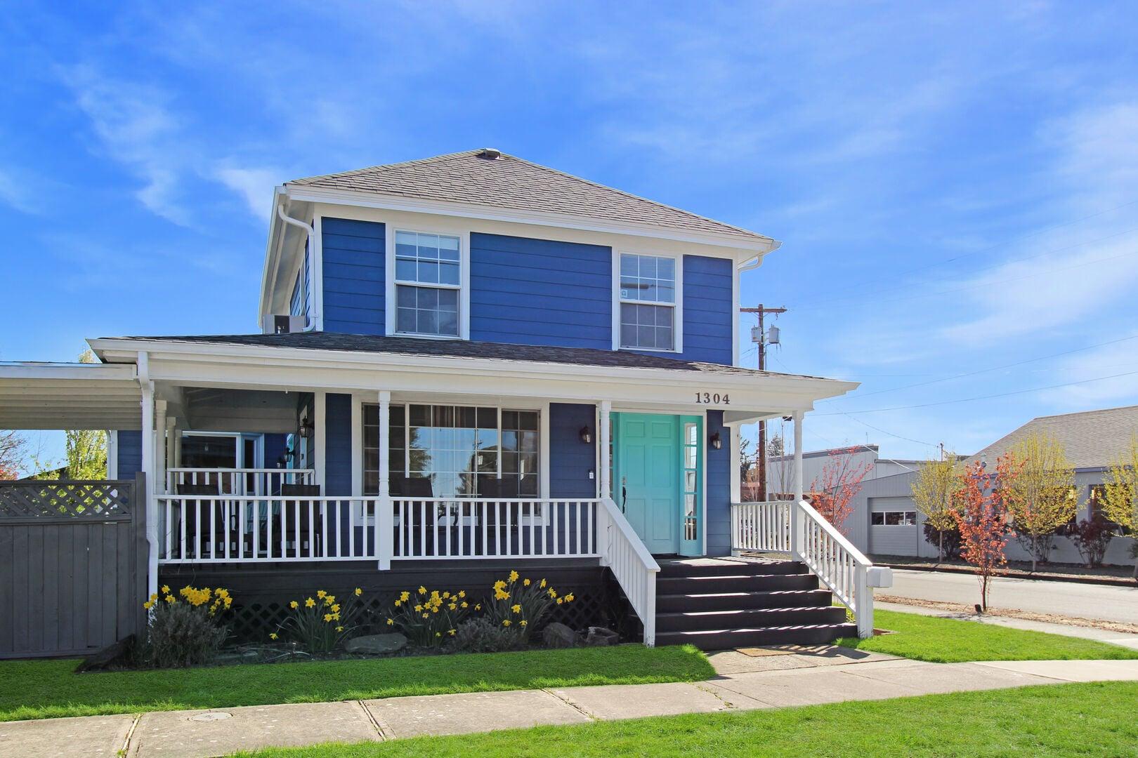 Two story blue house with large front porch.