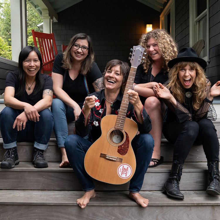 five women sitting on stairs of porch smiling