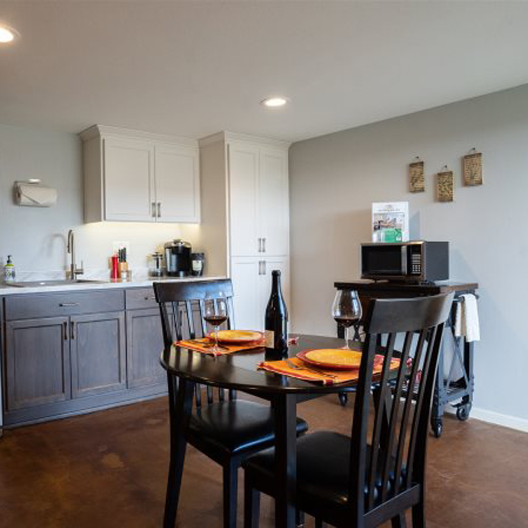 kitchen with small table, two chairs and microwave on cart