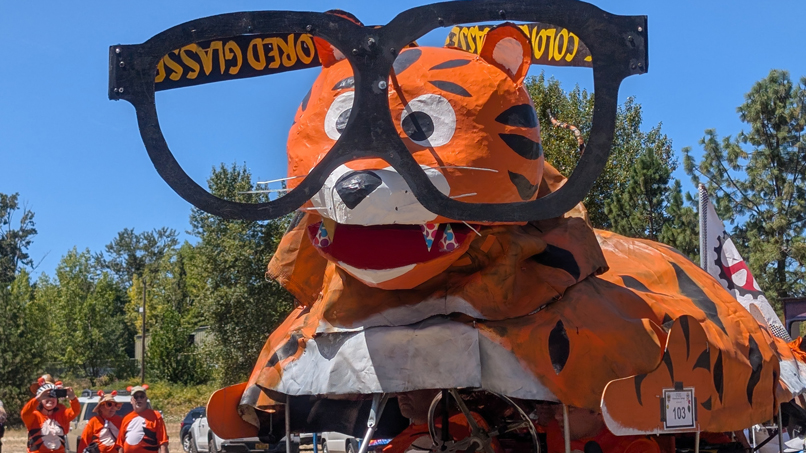Pedal powered machine shaped like a tiger with large glasses.