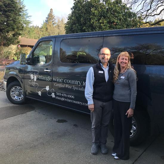 two people stand in front of touring van with lettering for Triangle Wine Country Tours