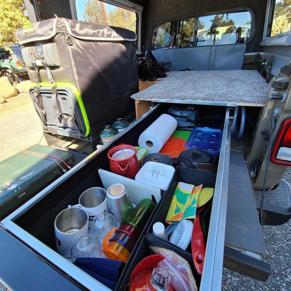 rear of adventure vehicle stocked with kitchen supplies