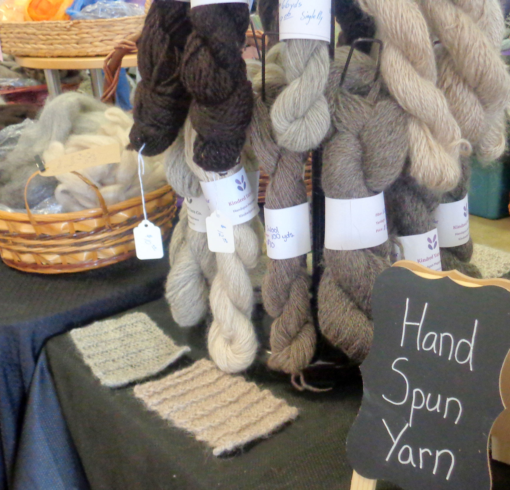 close up of display of hand spun yard atop a vendor table at fiber tradeshow