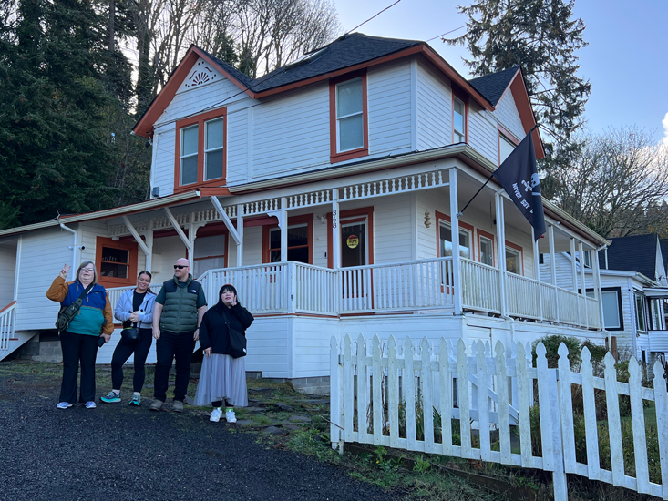 four people stand in front of the house featured in The Goonies movie