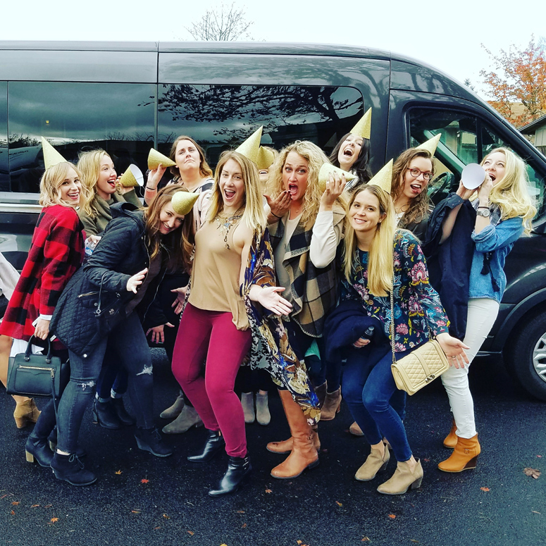 group photo of bachelorette party attendees in front of wine tasting touring van