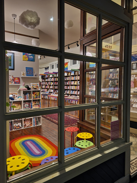 View into a bookstore with bright furniture and shelves.