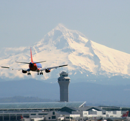 Southwest Airlines plane descending for landing at airport with mountain in background
