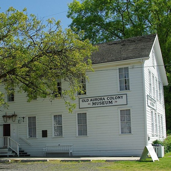 exterior of two story building with sign for Old Aurora Colony Museum