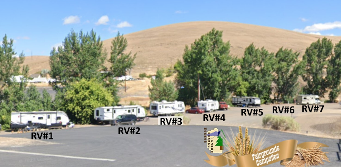 RVs parked near trees with Eastern Oregon high desert in background
