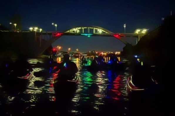 Group kayaks at night wearing glow sticks.