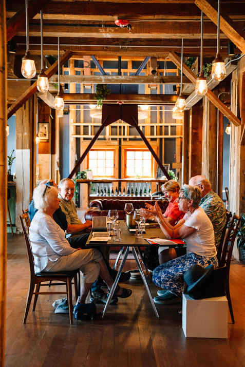 a party of six tastes wine in a rustic yet modern styled tasting room