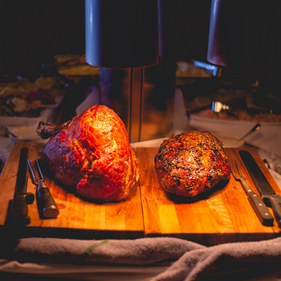 ham and new york striploin steak on a wooden cutting board
