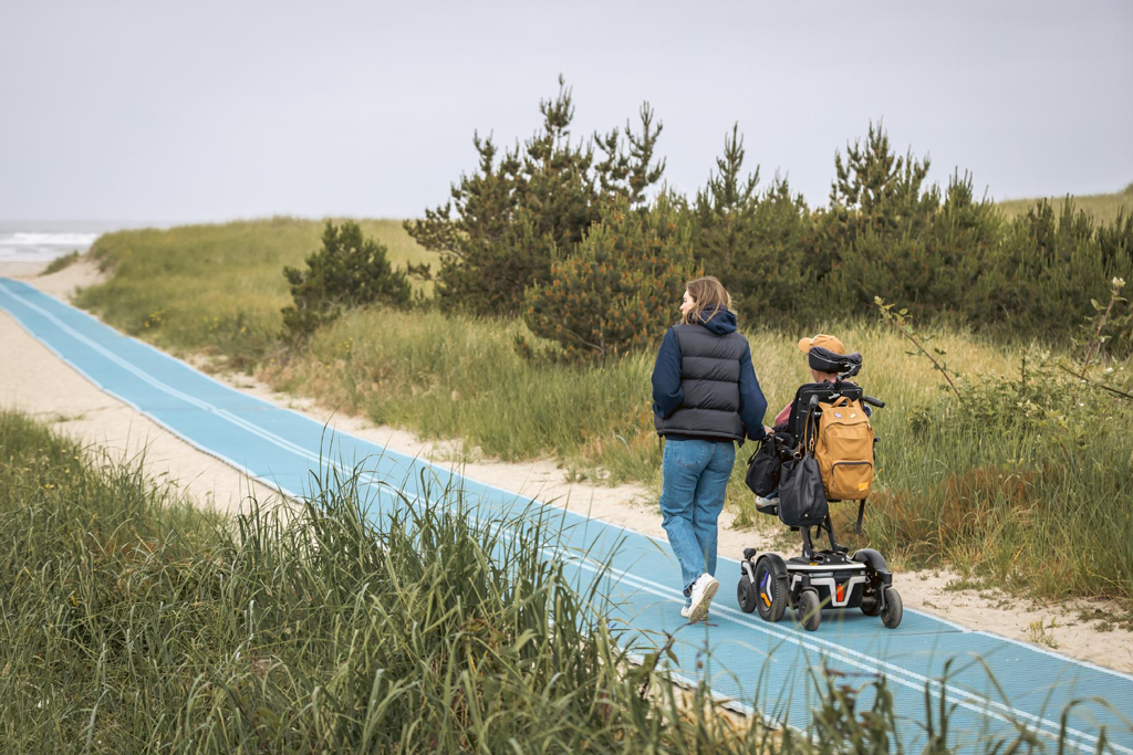 a wheelchair user on a mobility mat on Oregon coast beach