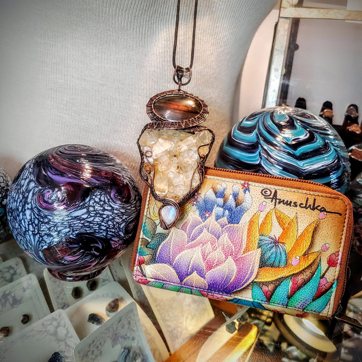 boutique display of earrings, glass float, rock necklace and wallet