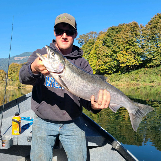 man wearing sunglasses holds large fish